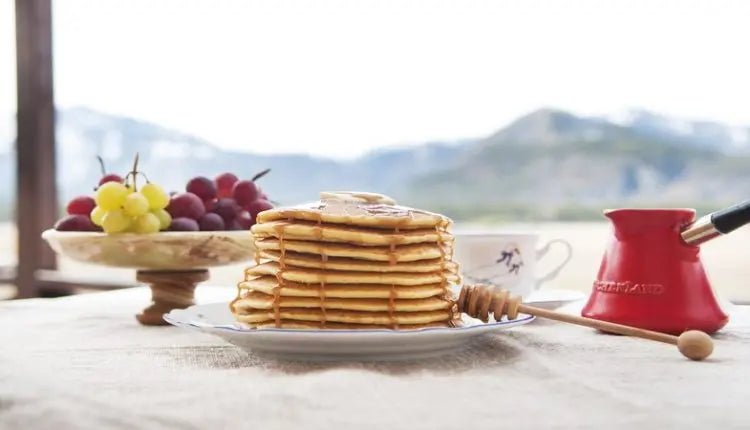 Colazione con pancake, uva e moka su un tavolo
